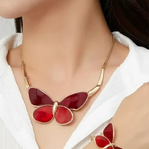 Woman wearing Belle Miss ALBINENN gold necklace with large red resin butterfly. Jewelry gift Cyprus.