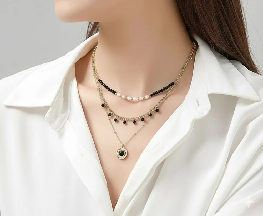Belle-Miss-UMENO-Black-Triple-Chain-Pearl-Necklace-Jewelry-Gift-1B Γυναίκα φοράει το Belle Miss UMENO κολιέ με τριπλή αλυσίδα επιχρυσωμένου ατσαλιού, μαύρες πέρλες και φυσικές πέτρες.