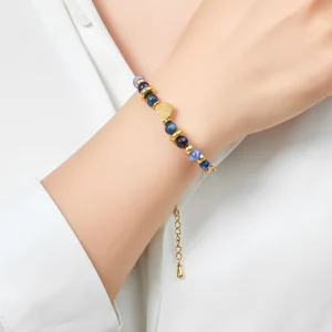 Woman wears Belle Miss VITALIE bracelet, gold-plated stainless steel chain with natural blue tinted stones and small heart motifs. Jewelry gift Cyprus