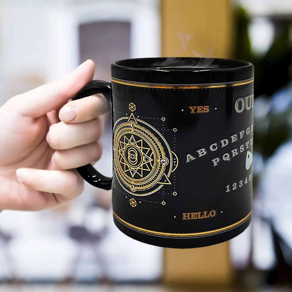 Magic Ouija Heat Change Ceramic Mug revealing a spirit board when hot hand